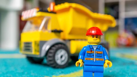 LEGO man in front of construction truck