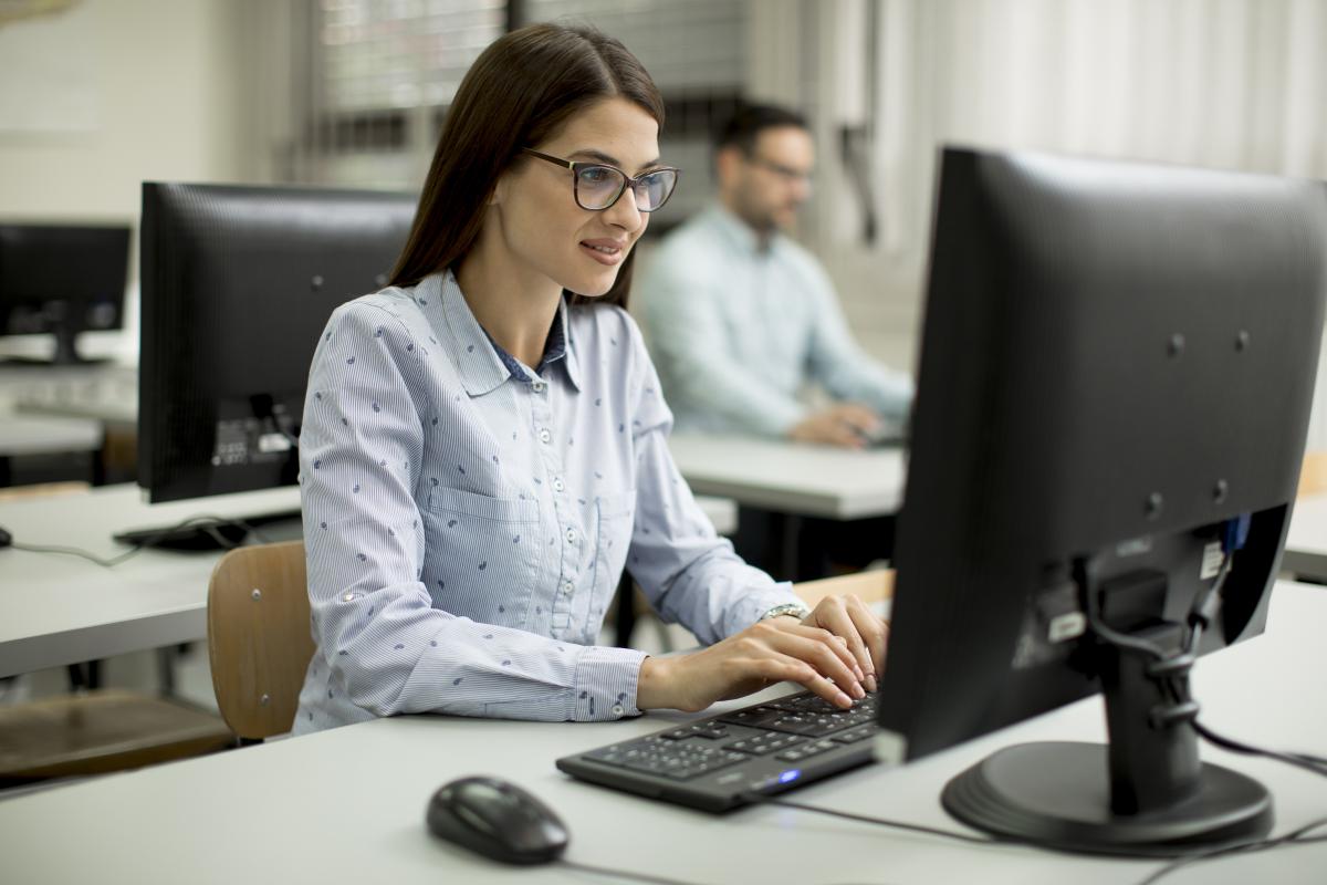 Woman at a computer in a classroom.